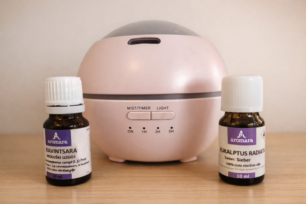 Pink essential oil diffuser with Ravintsara and Eucalyptus radiata bottles—my family-friendly winter diffuser setup.