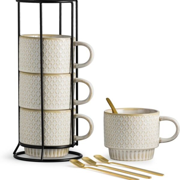 Beige stackable ceramic coffee mug set with black stand and gold spoons on a light background