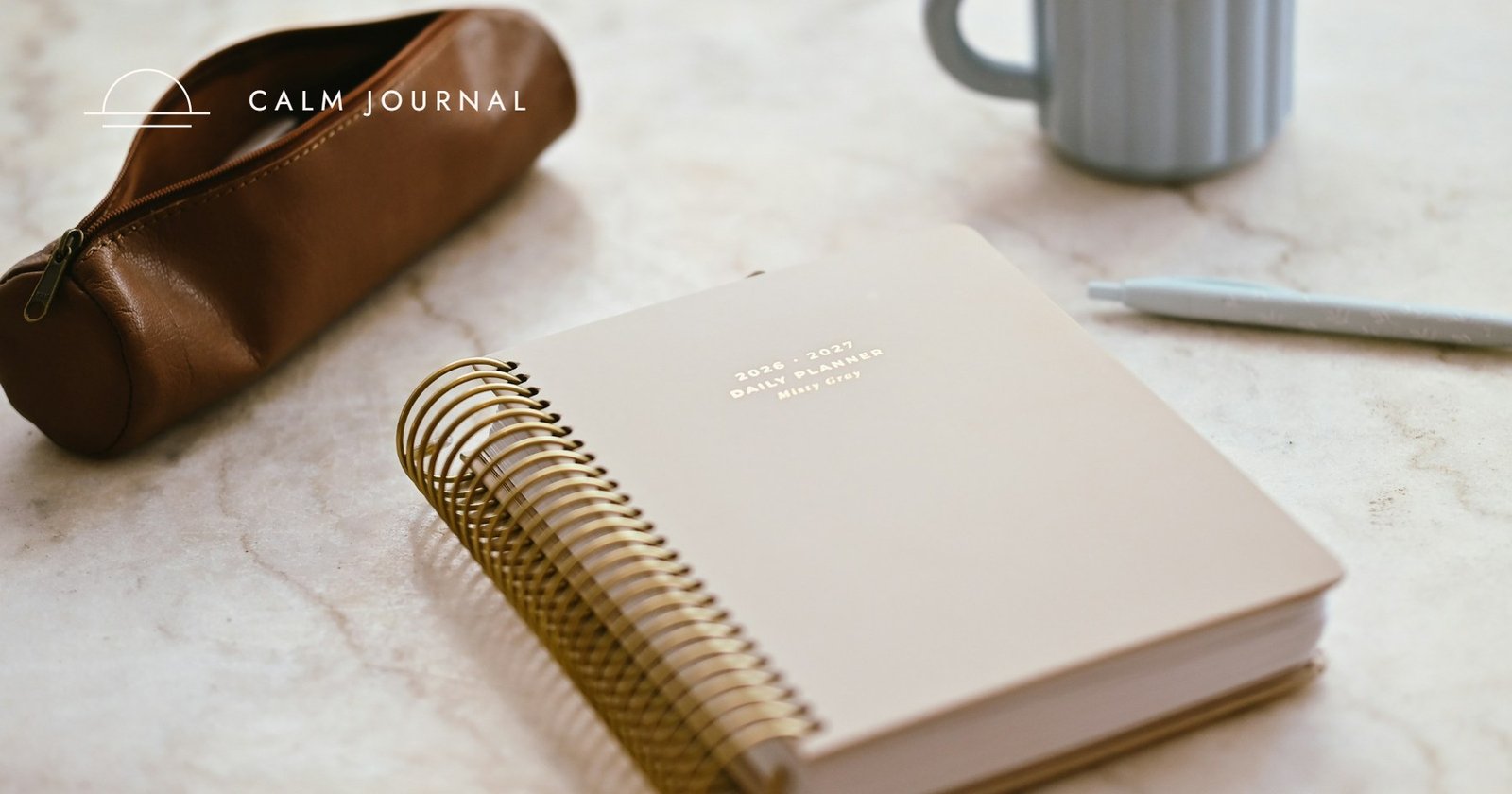 Spiral-bound planner on marble with a mug, Calm Journal cover for the post on what a Done List is